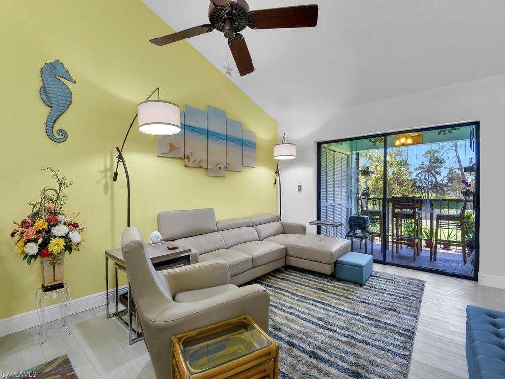 5825 Rattlesnake Hammock Road, Unit 202 Naples, FL 34113 - Photo 6 of 30 a living room with furniture and a floor to ceiling window