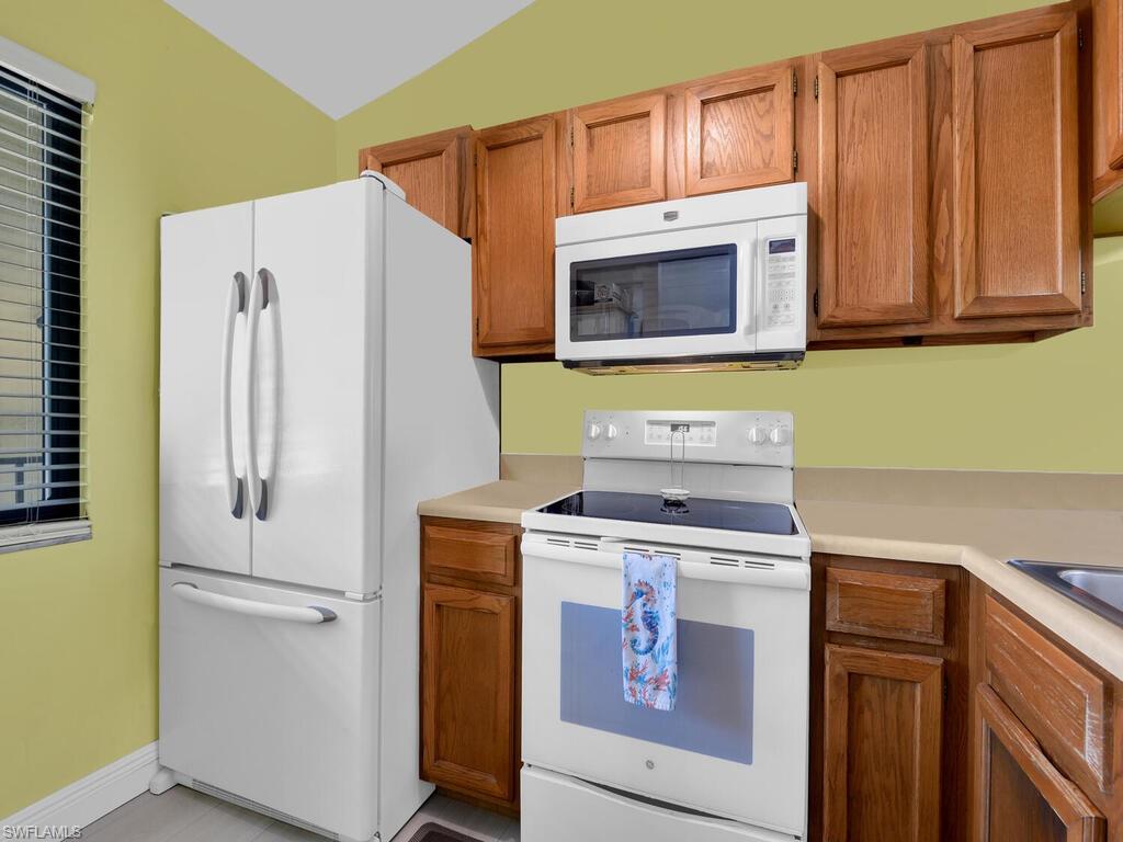5825 Rattlesnake Hammock Road, Unit 202 Naples, FL 34113 - Photo 8 of 30 a kitchen with a refrigerator stove and microwave