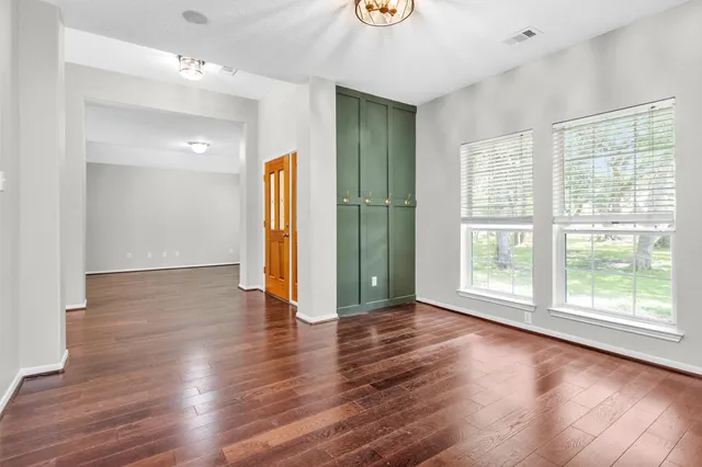 a view of empty room with wooden floor