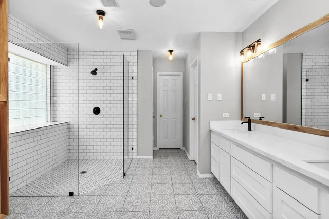 a view of an empty room and chandelier fan