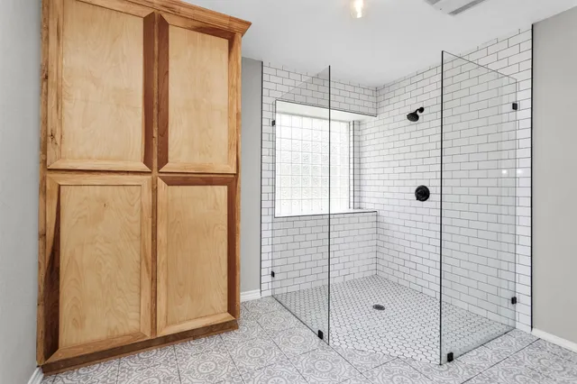 a spacious bathroom with a shower sink and mirror