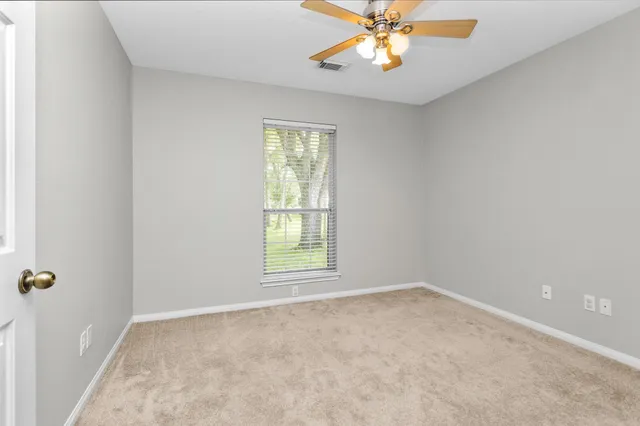 a view of a livingroom with a window and a ceiling fan