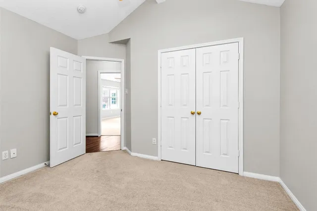 an empty room with windows and chandelier fan