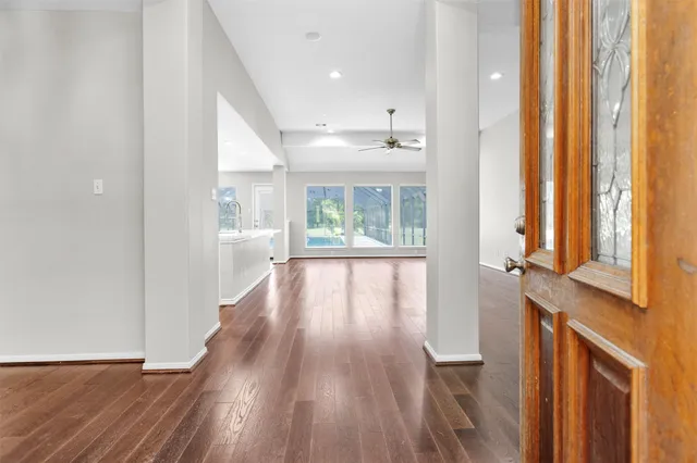a view of a hallway with wooden floor and windows