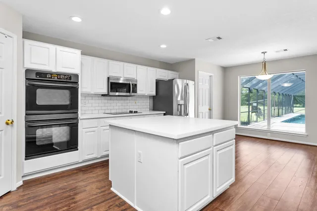 a view of a kitchen with a stove cabinets and wooden floor