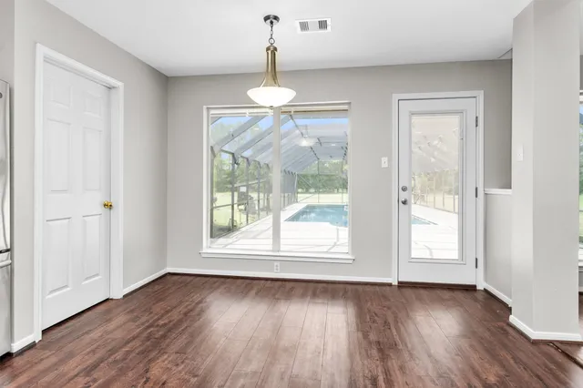 a large kitchen with cabinets wooden floor and stainless steel appliances