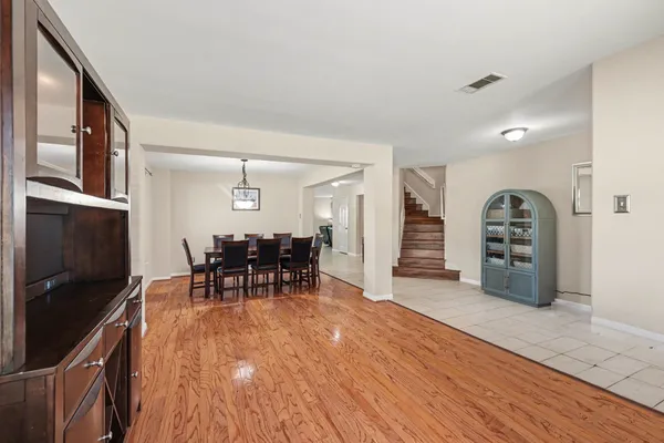 a view of a living room and a kitchen with wooden floor