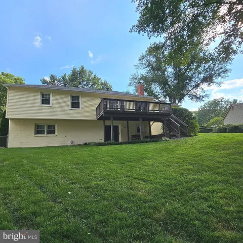 a view of a house with a yard and a tree