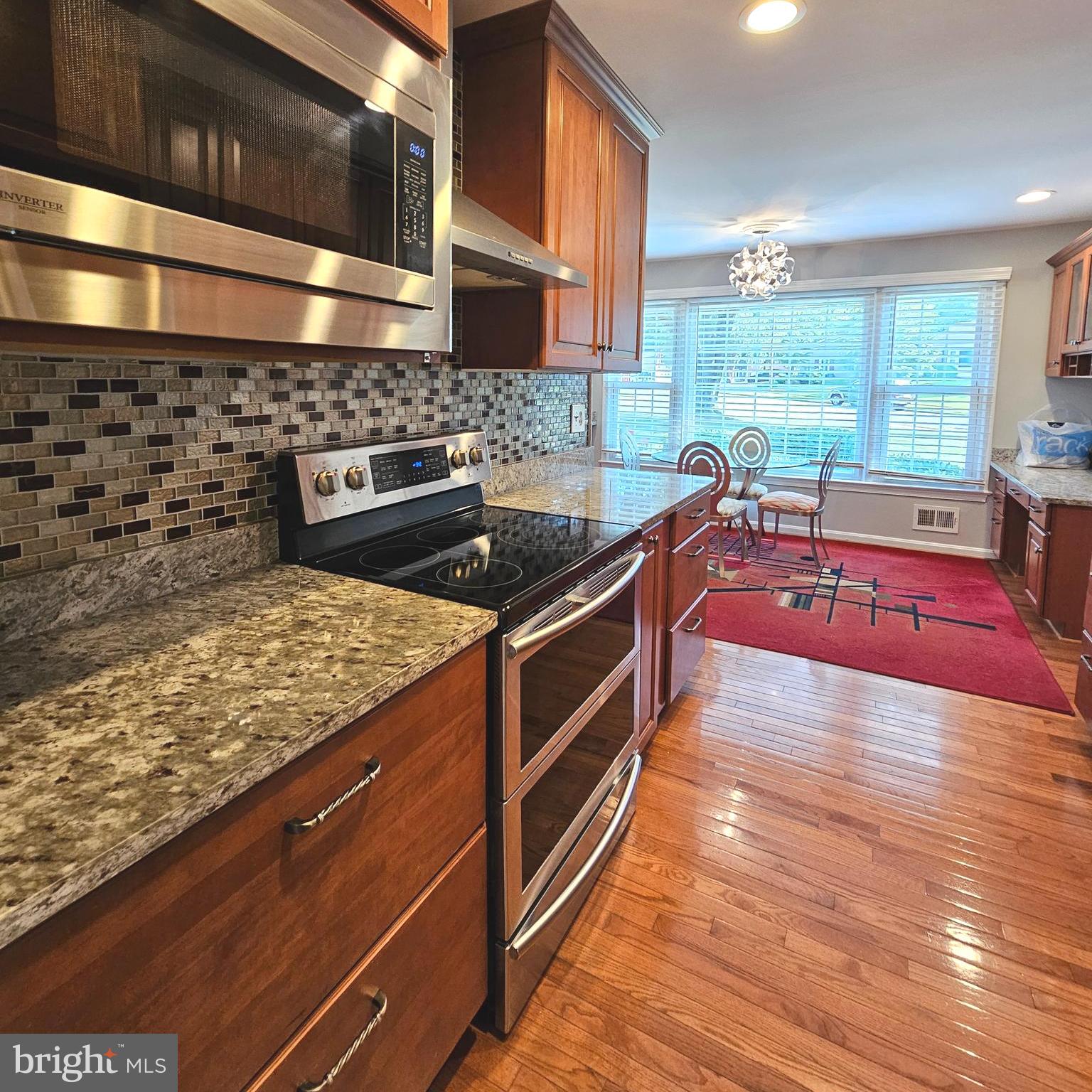 7777 Turlock Road Springfield, VA 22153 - Photo 8 of 43 a large kitchen with stainless steel appliances granite countertop a stove a sink and a microwave