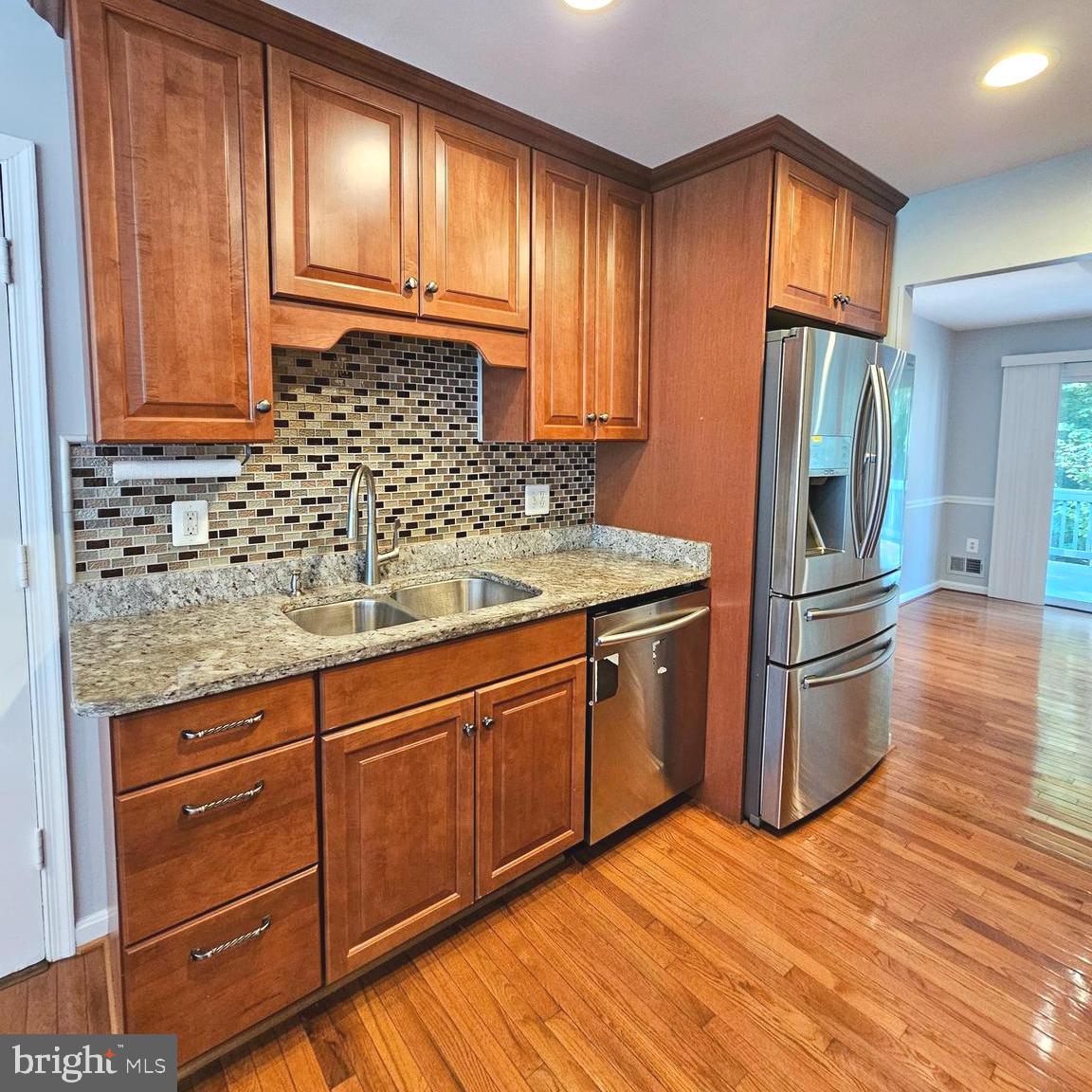 7777 Turlock Road Springfield, VA 22153 - Photo 10 of 43 a kitchen with stainless steel appliances granite countertop a refrigerator a stove a sink and dishwasher with wooden cabinets