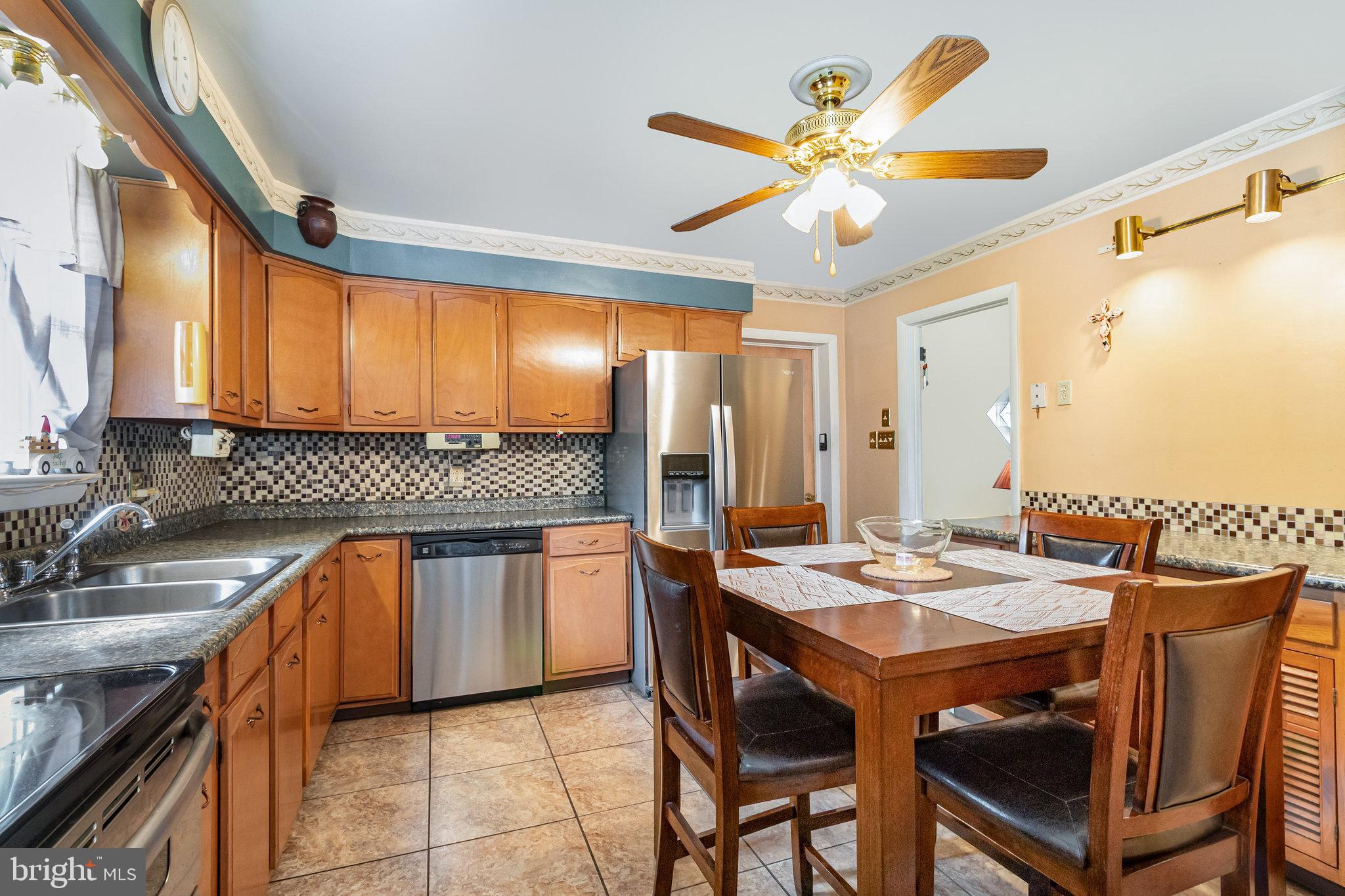 414 Trudy Road Harrisburg, PA 17109 - Photo 7 of 26 a kitchen with stainless steel appliances granite countertop a sink a stove a dining table and chairs