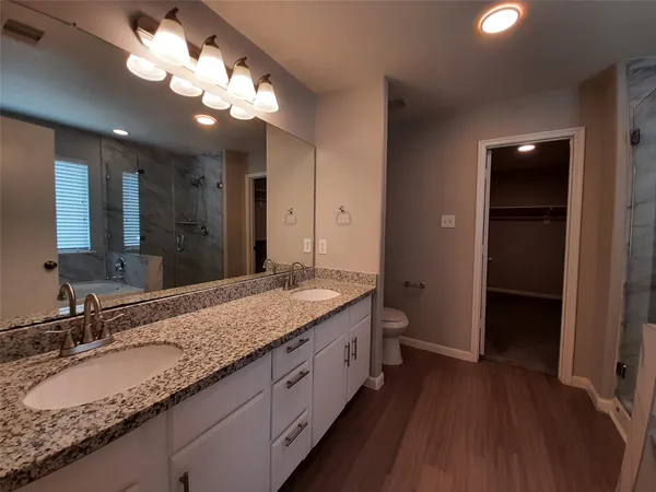 a bathroom with a granite countertop double vanity sink and a mirror