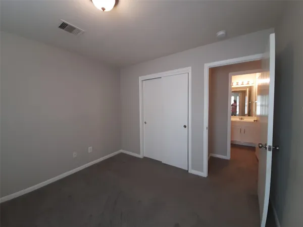 an empty room and a bathroom