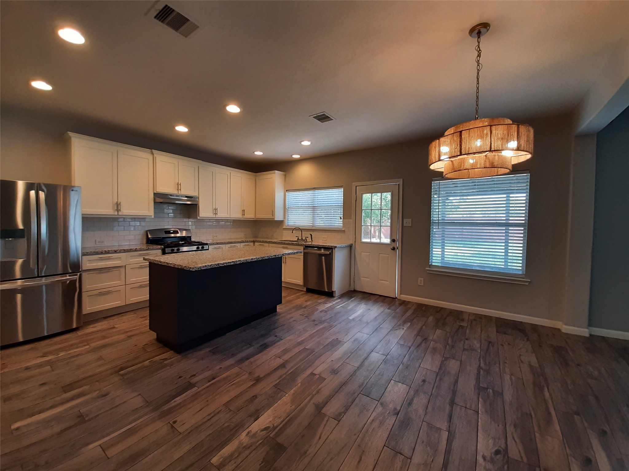 20526 Rustic Rail Court Cypress, TX 77433 - Photo 8 of 23 a large kitchen with stainless steel appliances granite countertop a stove a refrigerator a sink dishwasher and a oven with wooden floor