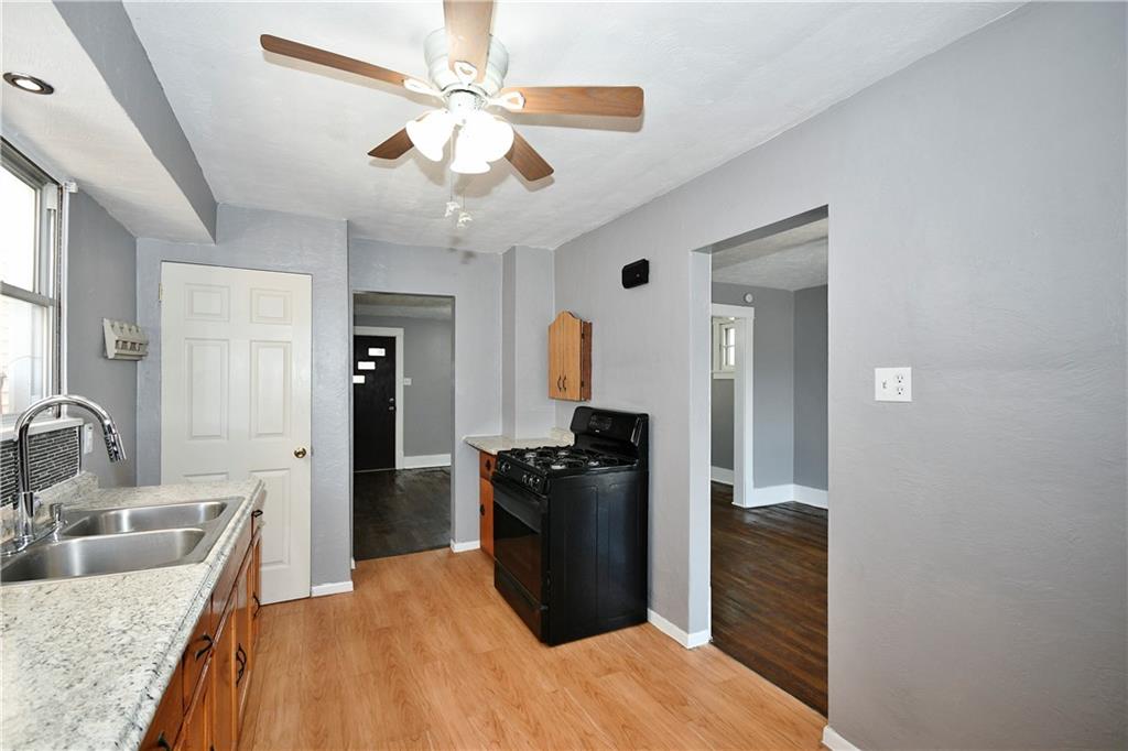 335 Mercer Street Turtle Creek, PA 15145 - Photo 12 of 25 a kitchen with a refrigerator a sink and dishwasher a oven with wooden floor
