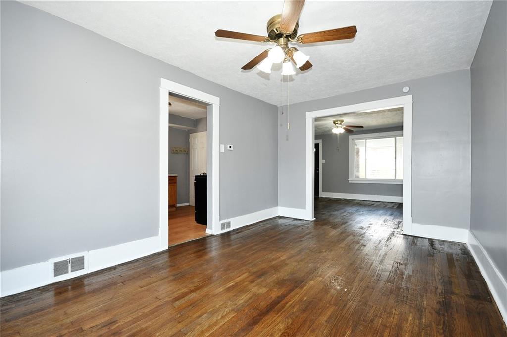 335 Mercer Street Turtle Creek, PA 15145 - Photo 8 of 25 an empty room with wooden floor and a ceiling fan