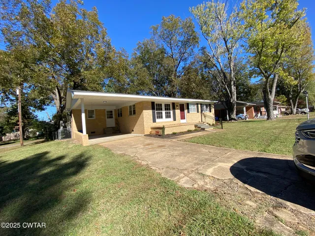 a view of a house with a yard and tree s