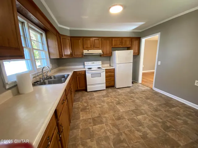 a kitchen with a refrigerator and a stove top oven