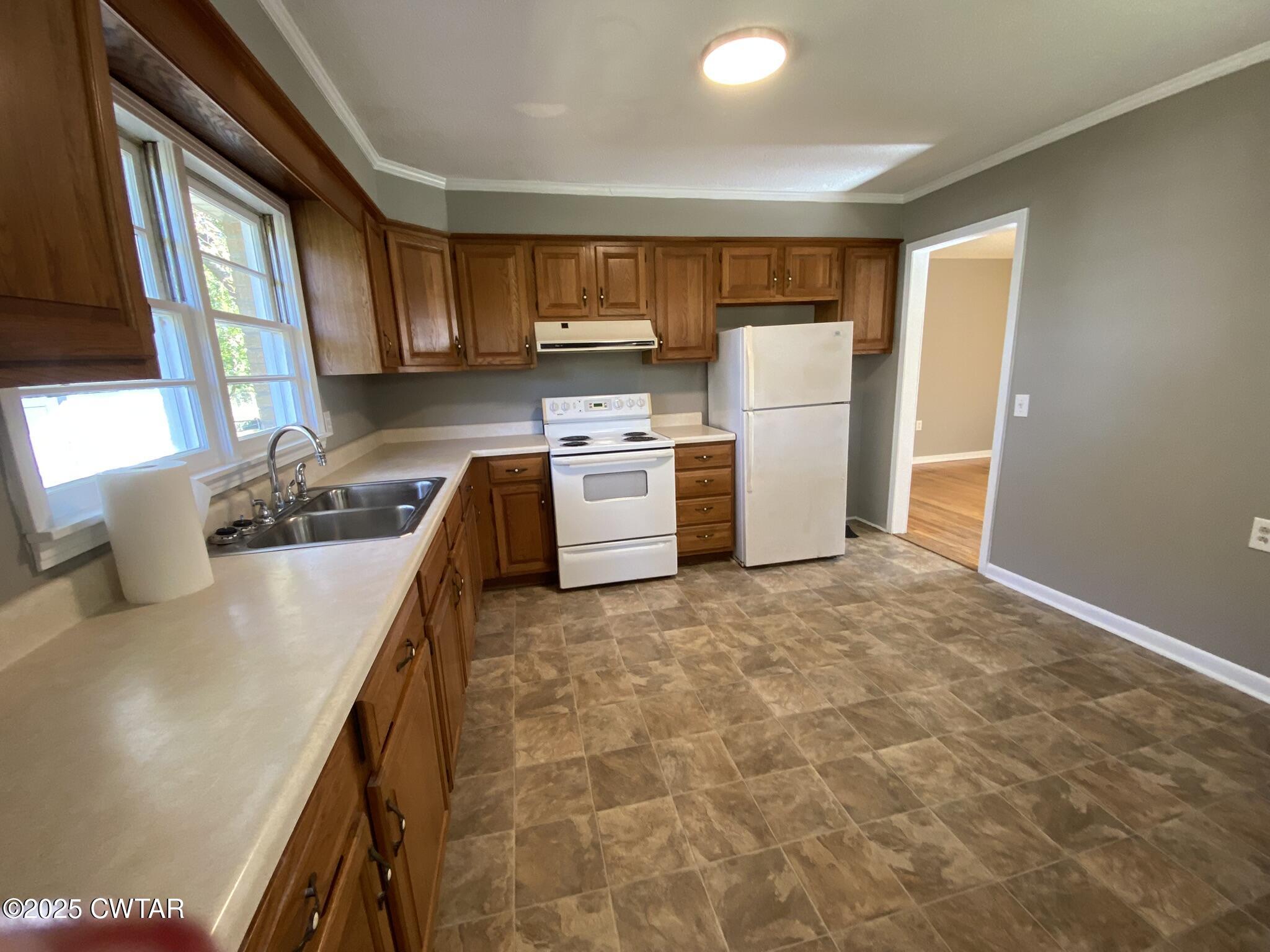437 East 2nd Street Henderson, TN 38340 - Photo 3 of 16 a kitchen with a refrigerator and a stove top oven