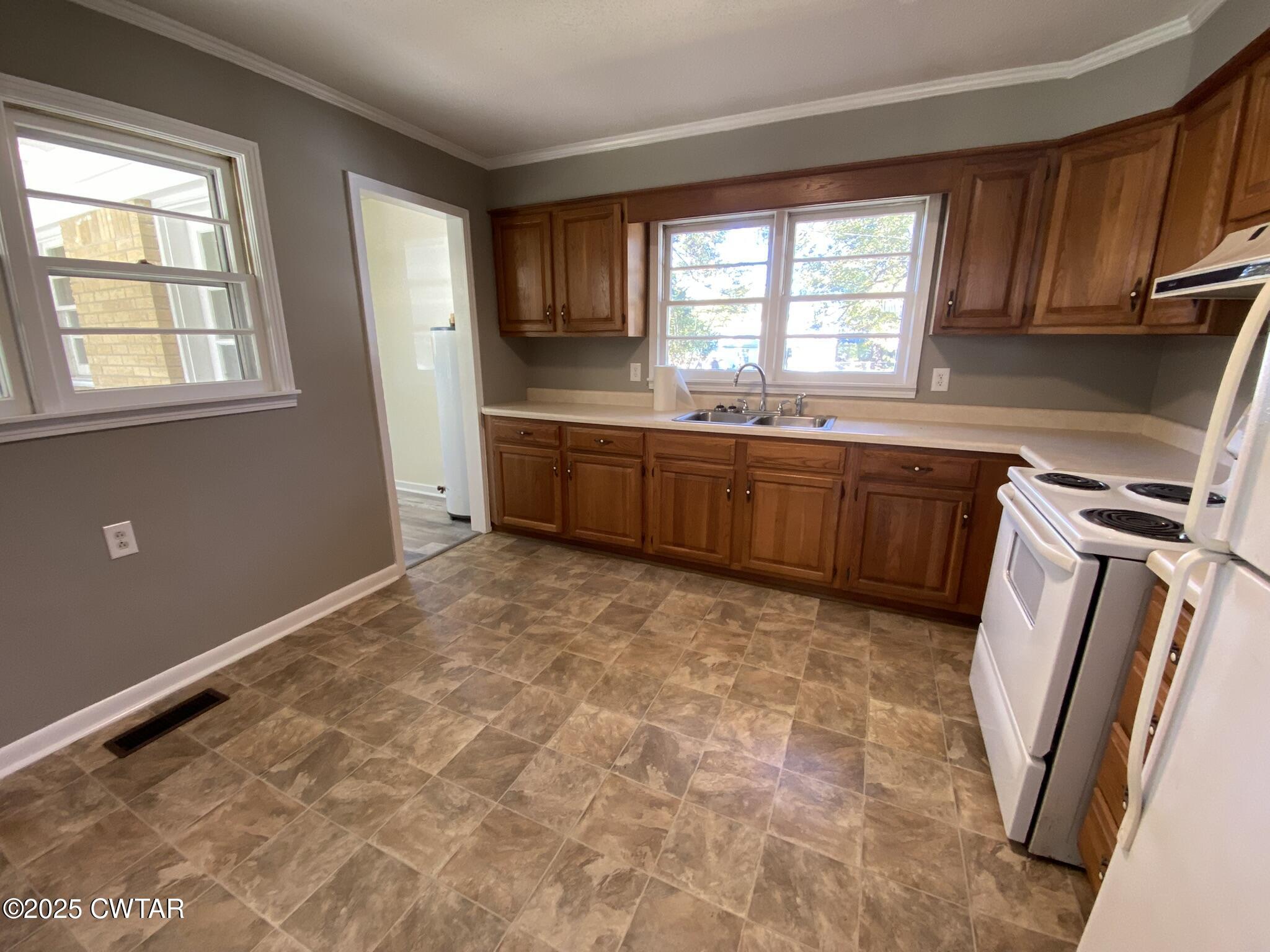 437 East 2nd Street Henderson, TN 38340 - Photo 5 of 16 a kitchen with granite countertop a sink window and cabinets