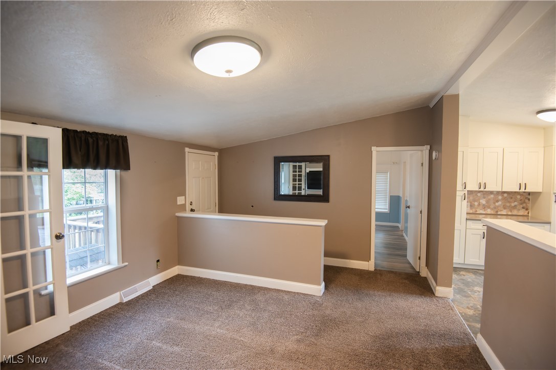 4594 Center Road Andover, OH 44003 - Photo 10 of 39 Unfurnished room with lofted ceiling and dark colored carpet