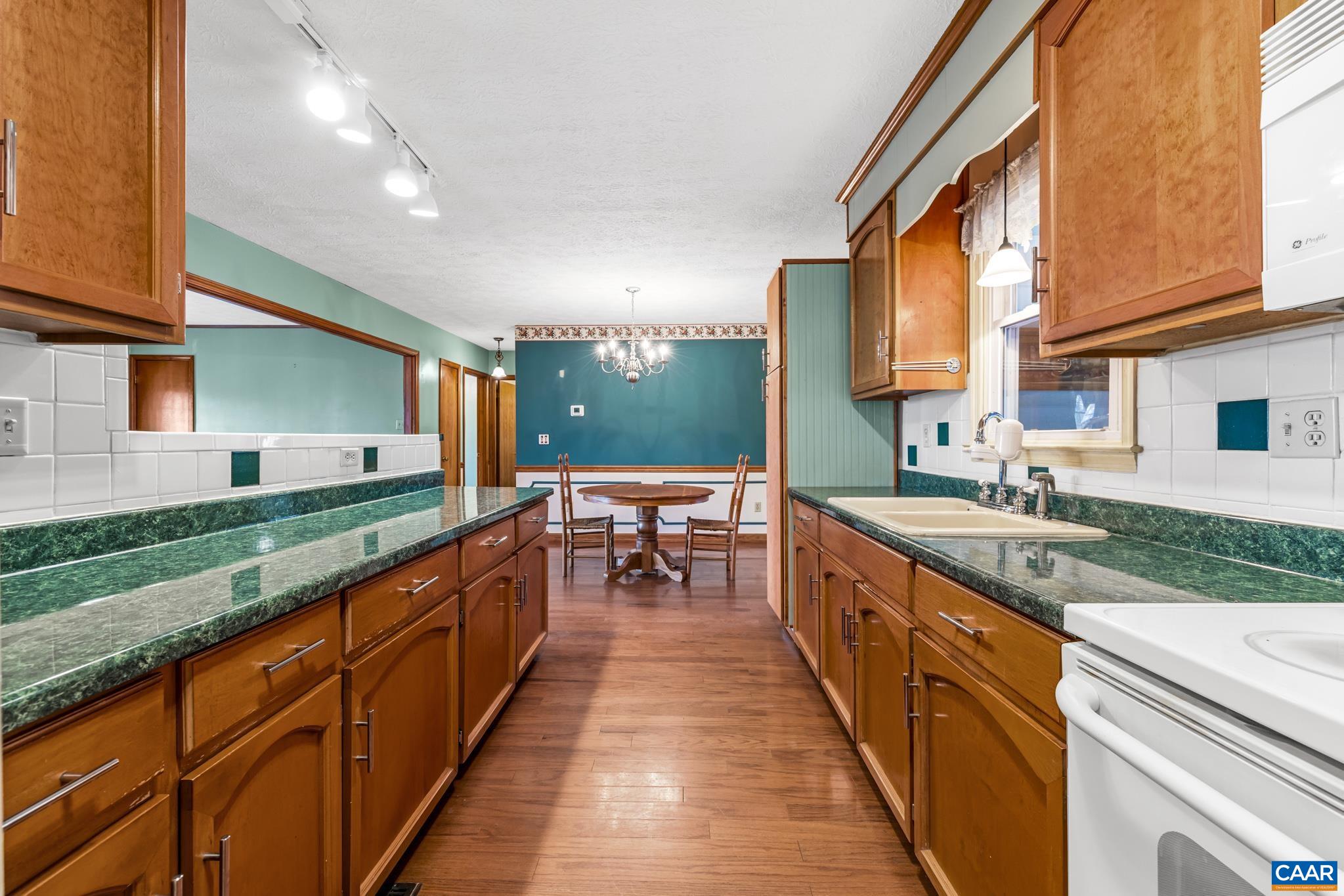 987 Matthew Mill Road Ruckersville, VA 22968 - Photo 11 of 63 a large kitchen with stainless steel appliances granite countertop a large counter top a stove and a sink