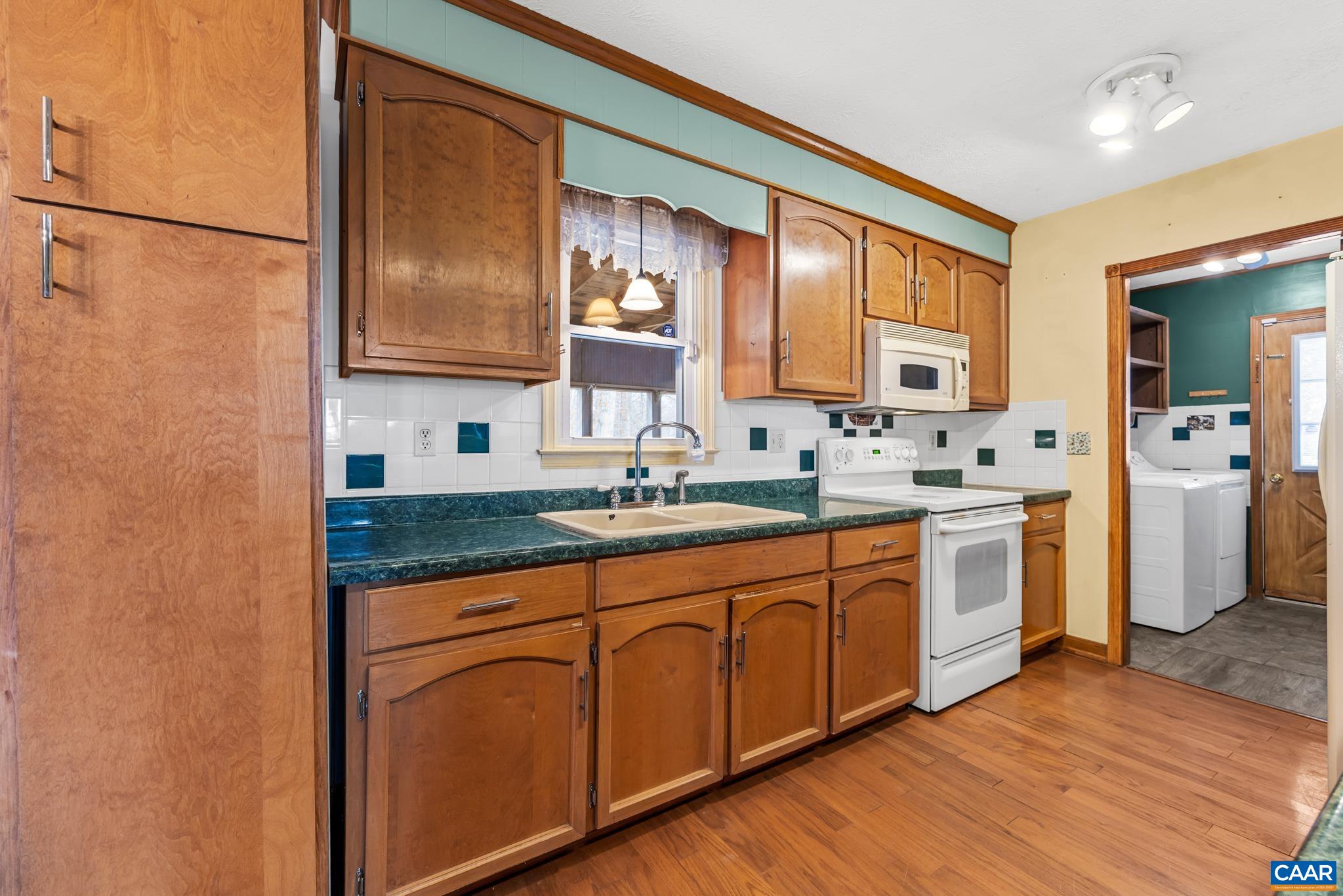 987 Matthew Mill Road Ruckersville, VA 22968 - Photo 3 of 63 a kitchen with stainless steel appliances granite countertop a sink cabinets and wooden floor
