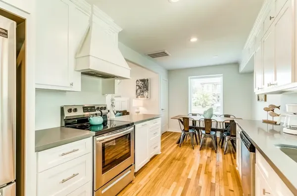 a kitchen with a table chairs stove and cabinets