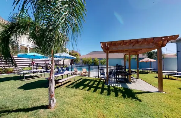 a patio with tables and chairs pool and a fire pit