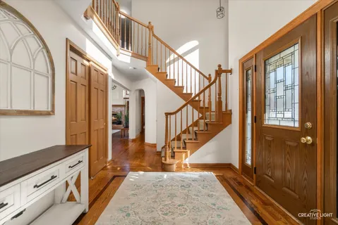 a view of an entryway with wooden floor and staircase