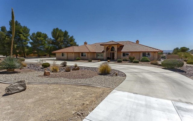 18905 Pachappa Road Apple Valley, CA 92307 - Photo 1 of 1 a patio with a table and chairs under an umbrella