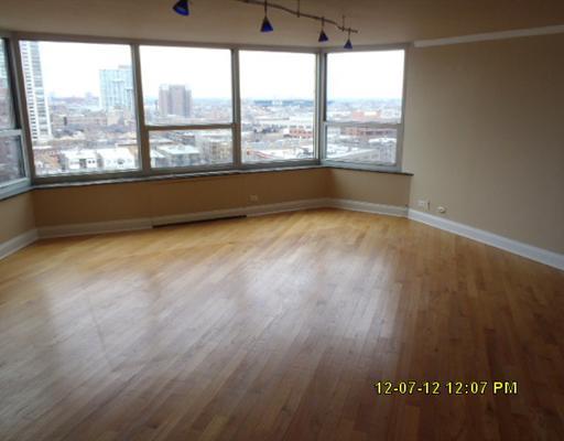 720 West Gordon Terrace, Unit 15L Chicago, IL 60613 - Photo 2 of 12 an empty room with wooden floor and windows