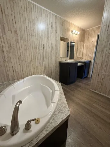 a bathroom with a tub sink and mirror