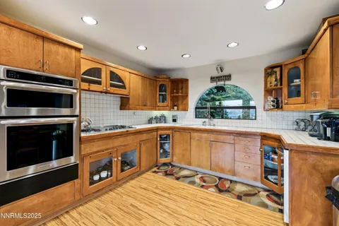 a view of living room with stainless steel appliances kitchen island a chandelier and fireplace