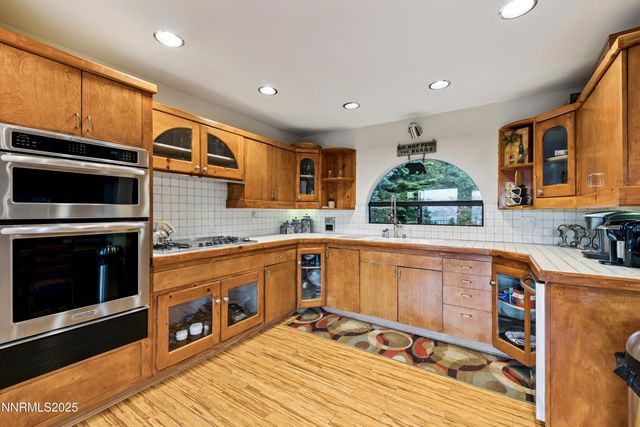 a view of living room with stainless steel appliances kitchen island a chandelier and fireplace