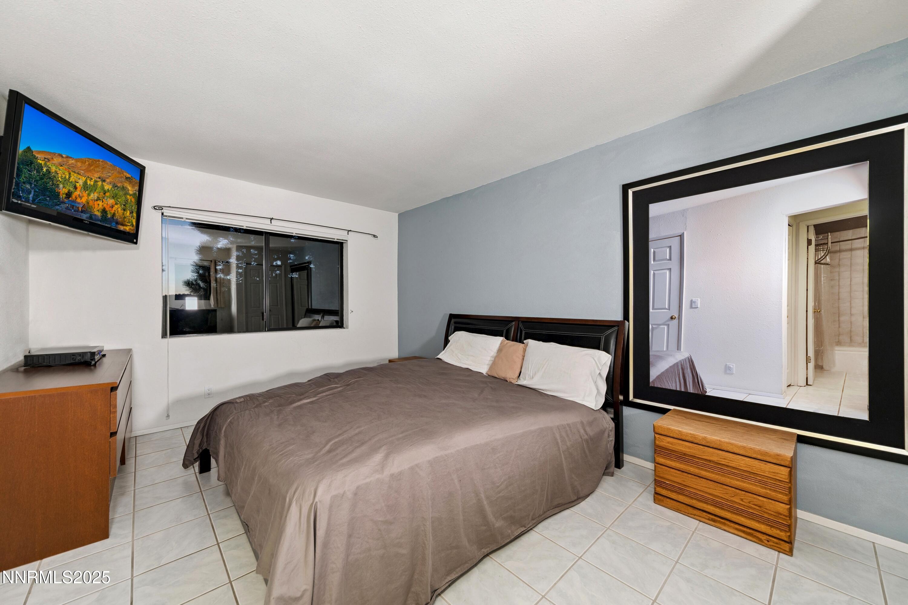 130 Granite Crest Drive Stateline, NV 89449 - Photo 83 of 85 a bedroom with a bed and a flat screen tv