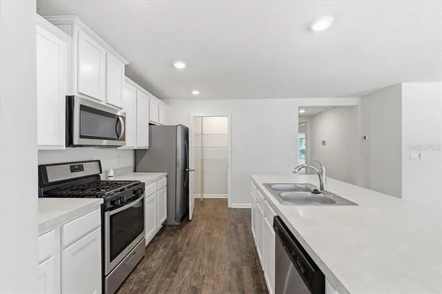 a kitchen with granite countertop stainless steel appliances cabinets a sink and a stove