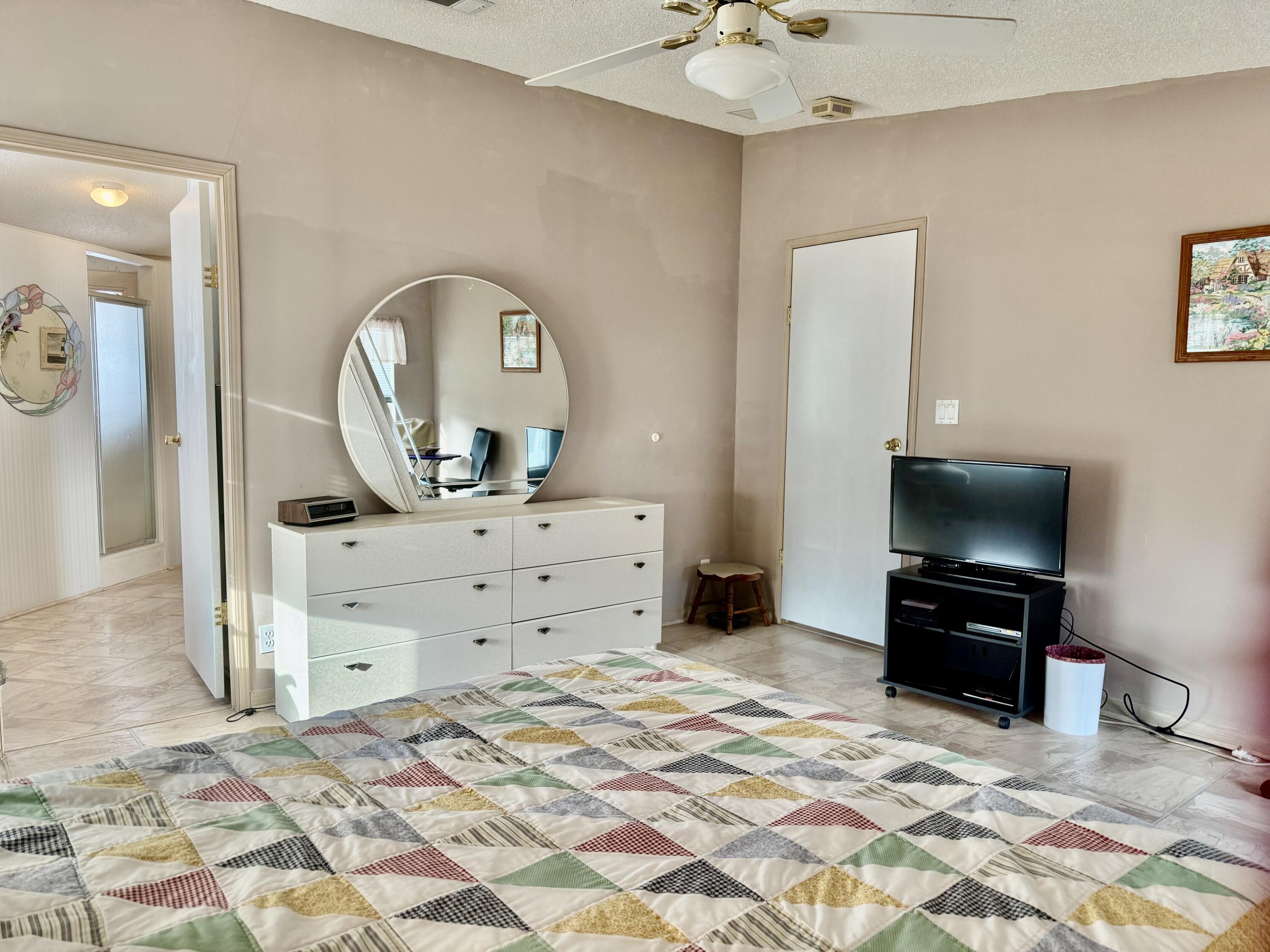 1704 Southwest 35th Circle Okeechobee, FL 34974 - Photo 20 of 44 a bed room with a bed a mirror and a television