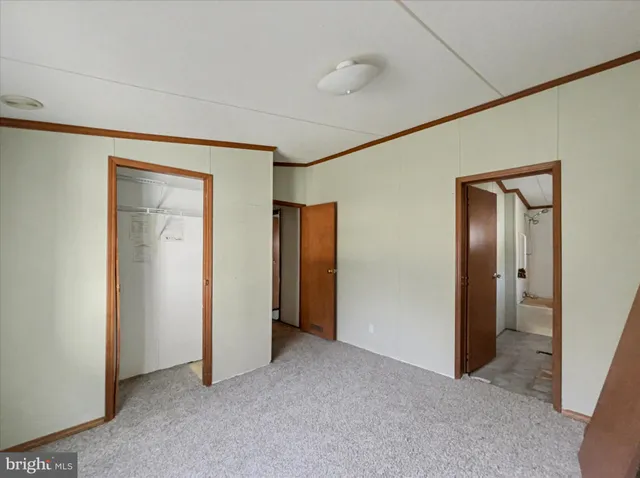 a view of an empty room with closet and wooden floor