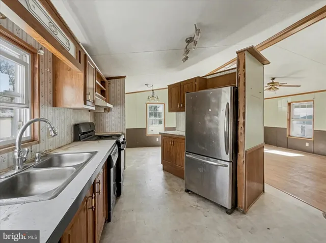 a kitchen with stainless steel appliances granite countertop a refrigerator and a sink