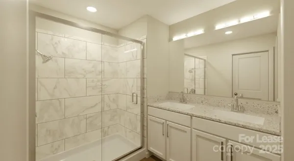 a bathroom with a sink shower and a mirror