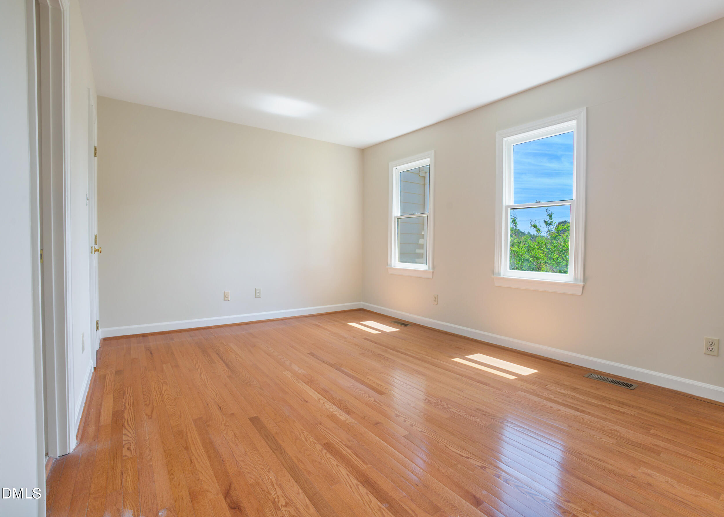 5018 Dunwoody Trail Raleigh, NC 27606 - Photo 12 of 24 an empty room with wooden floor and windows