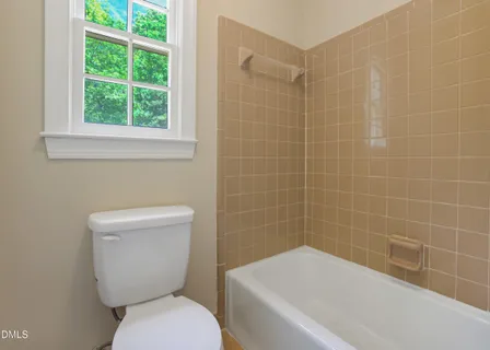 a white toilet sitting next to a bath tub