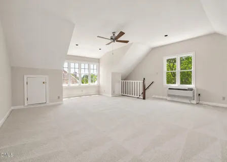 an empty room with windows and ceiling fan