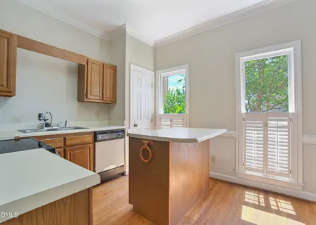 a kitchen with stainless steel appliances granite countertop wooden cabinets a stove a sink and a window