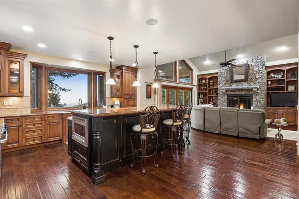 a kitchen with stainless steel appliances granite countertop a sink a counter space and wooden floor