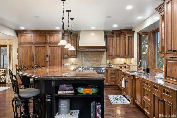 a kitchen with stainless steel appliances granite countertop a sink a stove and a refrigerator