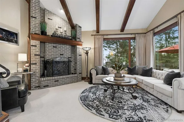 a living room with furniture a fireplace and a floor to ceiling window