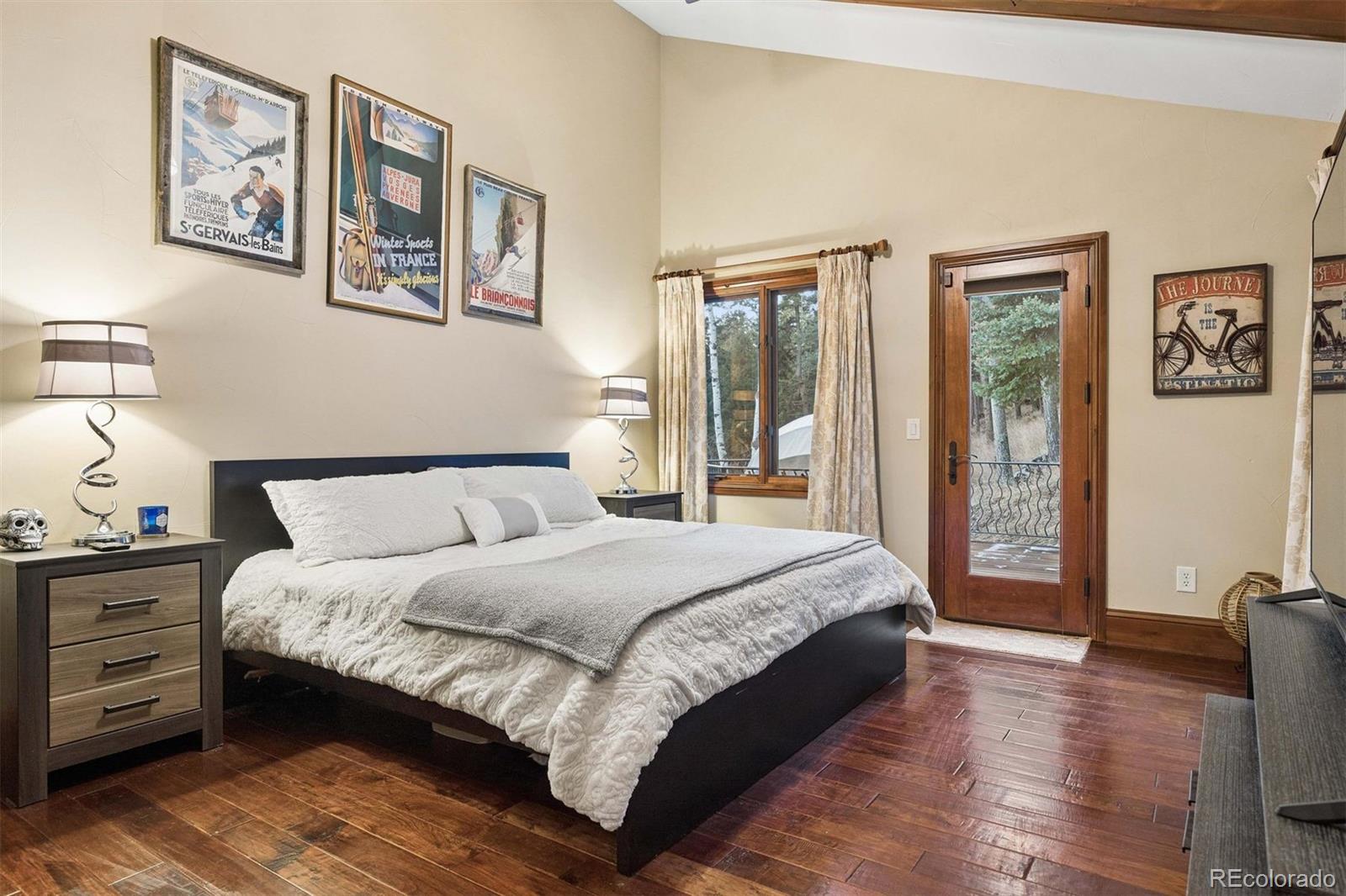 45 West Ranch Trail Morrison, CO 80465 - Photo 24 of 50 a bedroom with a large bed and a chandelier