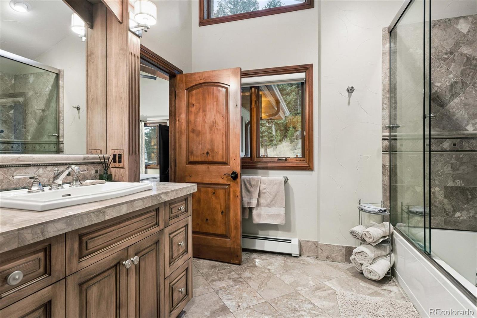 45 West Ranch Trail Morrison, CO 80465 - Photo 25 of 50 a bathroom with a granite countertop sink and a mirror